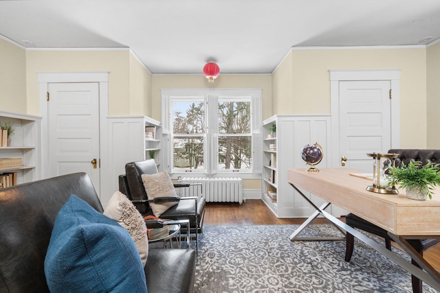 office space with dark wood-type flooring, ornamental molding, and radiator