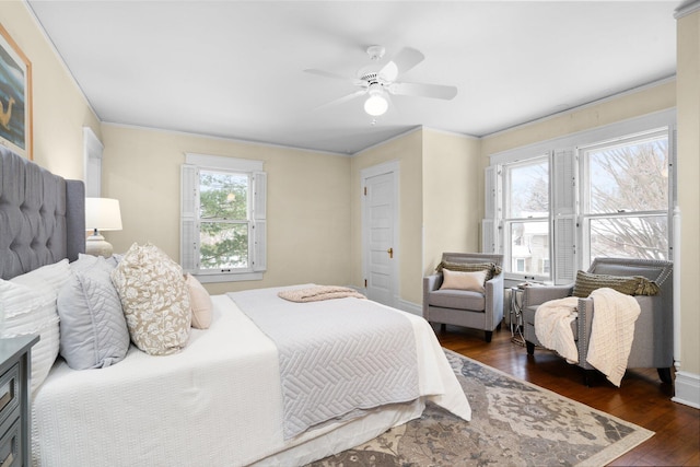 bedroom with ornamental molding, dark hardwood / wood-style floors, and ceiling fan