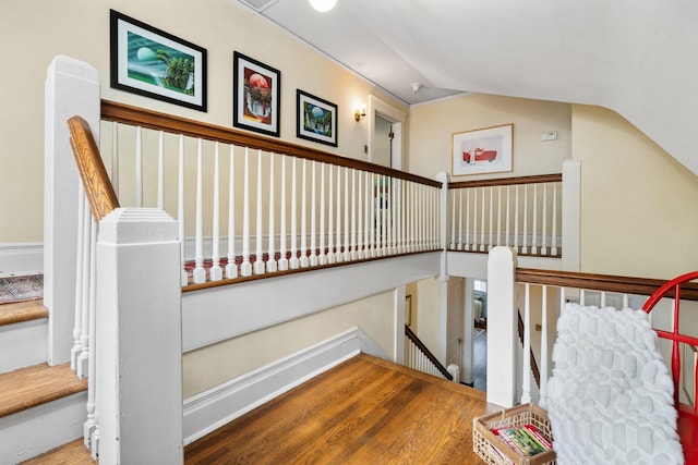 stairs with lofted ceiling and wood-type flooring