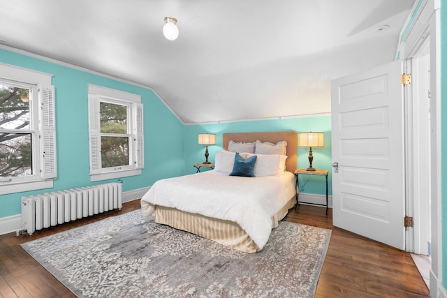 bedroom with radiator, dark wood-type flooring, and vaulted ceiling