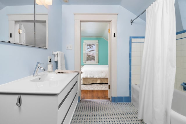 bathroom with shower / bath combo, lofted ceiling, and vanity