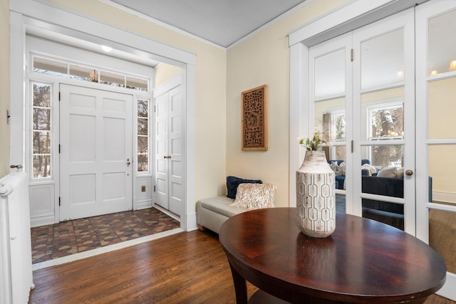 entrance foyer with crown molding and dark wood-type flooring