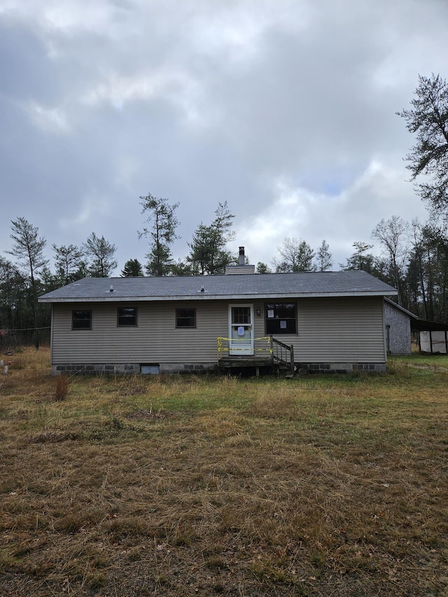 rear view of house featuring a lawn