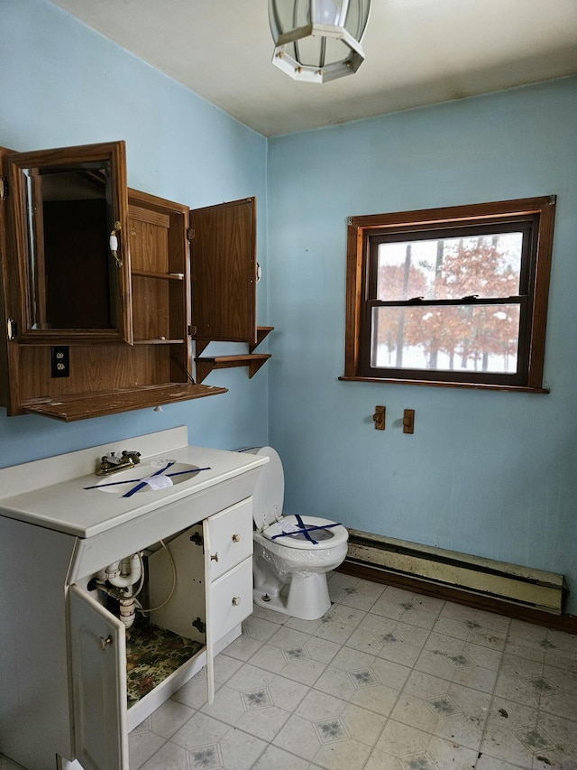 bathroom with sink, toilet, and baseboard heating