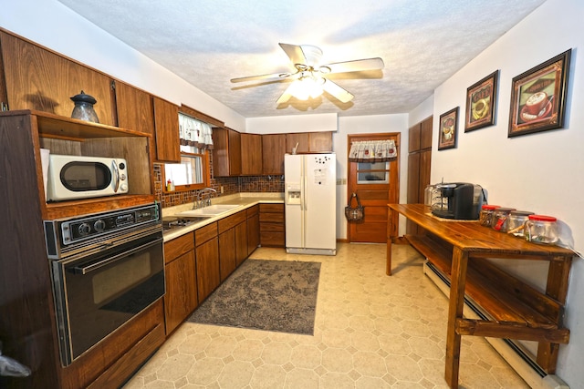 kitchen featuring sink, a textured ceiling, black oven, tasteful backsplash, and white fridge with ice dispenser