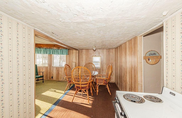 dining room featuring wooden walls and a textured ceiling