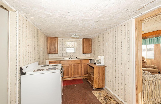 kitchen with a textured ceiling, white electric range oven, and sink