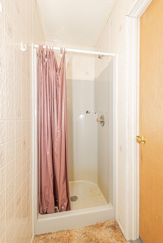 bathroom with tile walls and walk in shower