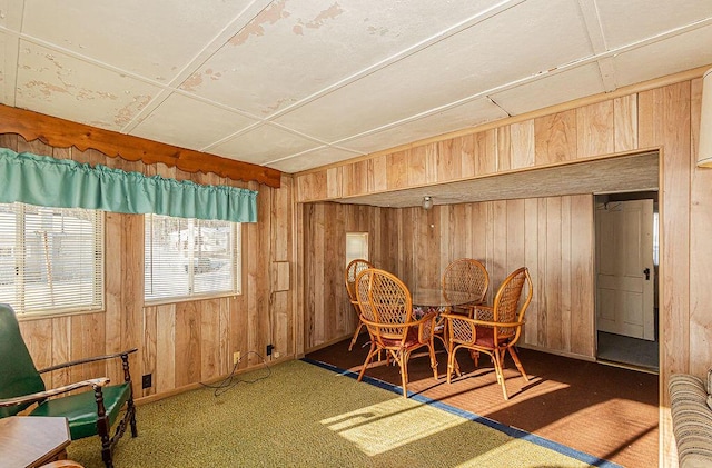 carpeted dining room with wood walls