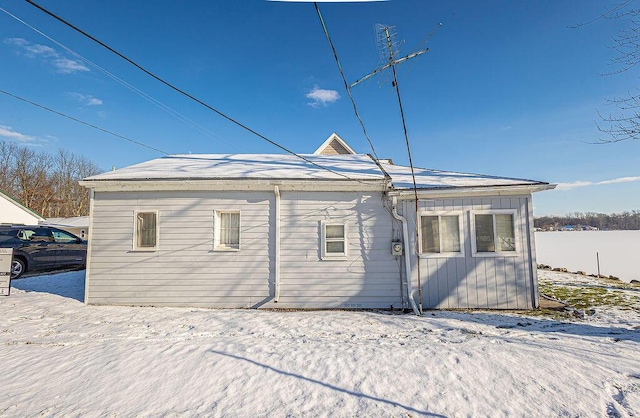 view of snow covered back of property