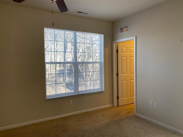 unfurnished room with light colored carpet and ceiling fan