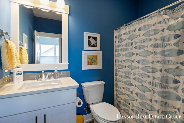 bathroom with a shower with shower curtain, vanity, and toilet