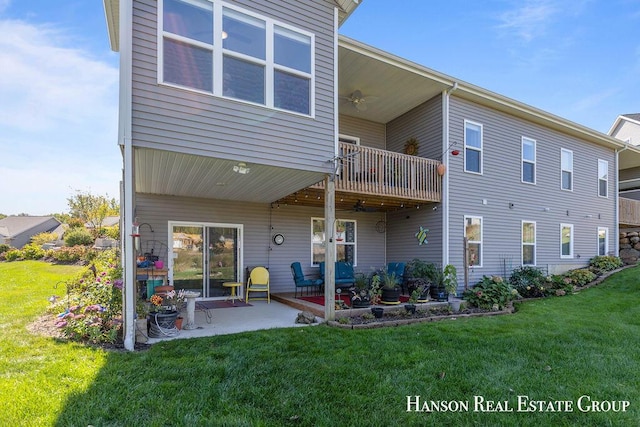 rear view of property with a yard, a patio, and a balcony