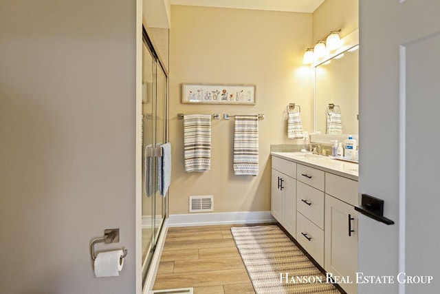 bathroom featuring vanity and a shower with shower door