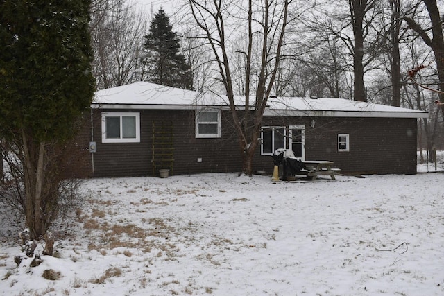 view of snow covered back of property