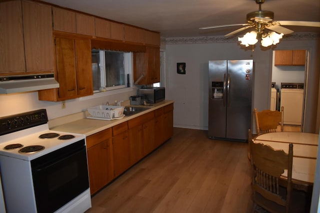 kitchen with sink, stainless steel refrigerator with ice dispenser, washer and dryer, white electric range oven, and extractor fan