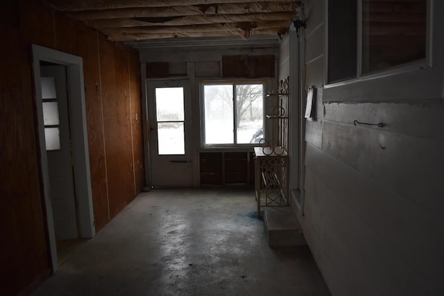 misc room featuring wood walls and concrete flooring