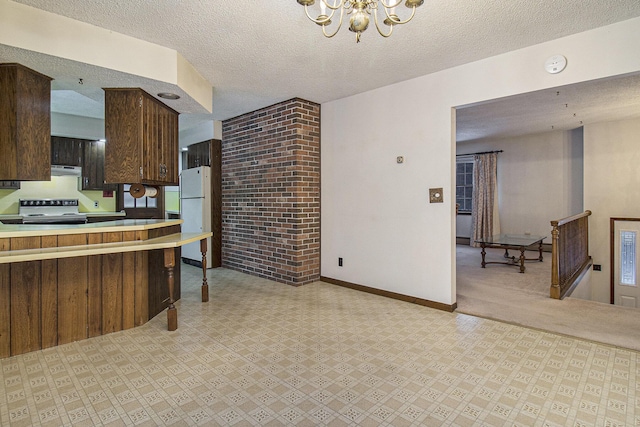 kitchen with range with electric cooktop, white fridge, a chandelier, and a textured ceiling