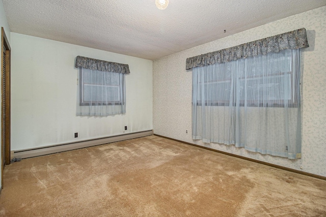 carpeted spare room with a baseboard radiator and a textured ceiling