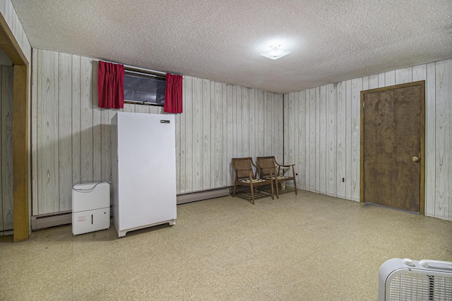 interior space featuring a textured ceiling and a baseboard heating unit