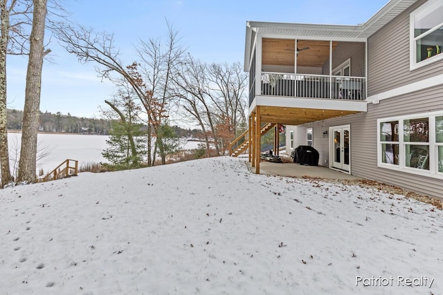 snowy yard with ceiling fan and french doors