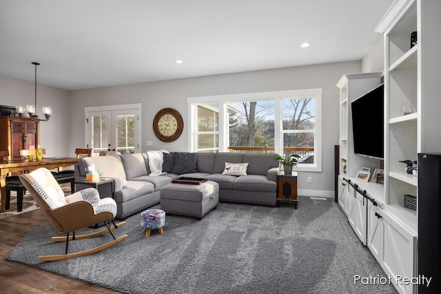 living room with an inviting chandelier and french doors