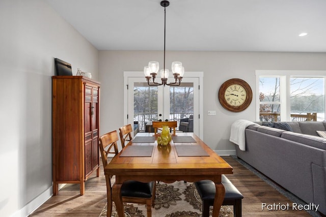 dining area featuring dark hardwood / wood-style flooring, plenty of natural light, and a notable chandelier