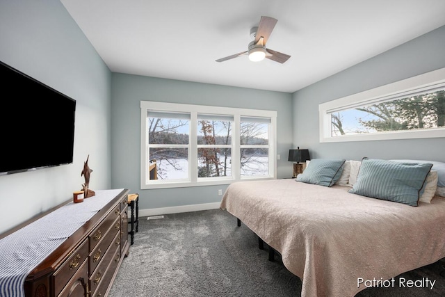 bedroom with ceiling fan, multiple windows, and carpet flooring