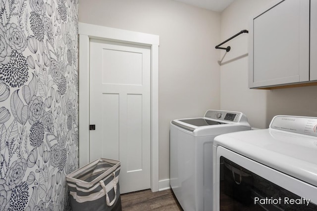 laundry room featuring washing machine and dryer, dark hardwood / wood-style flooring, and cabinets