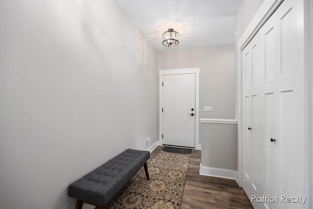 doorway with dark hardwood / wood-style flooring and an inviting chandelier