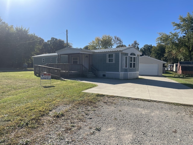 view of front facade featuring a garage, an outbuilding, and a front yard