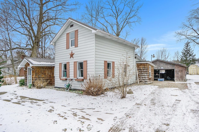 snow covered property featuring an outdoor structure