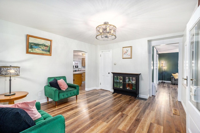 living area featuring hardwood / wood-style flooring and an inviting chandelier