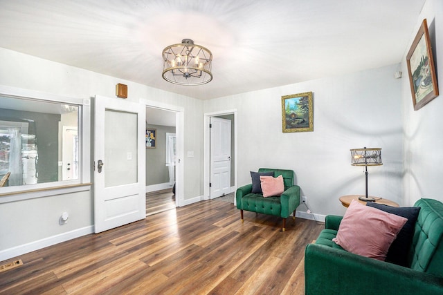 living area with dark wood-type flooring and a chandelier