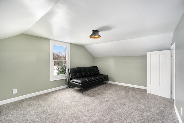 living area with carpet flooring and vaulted ceiling