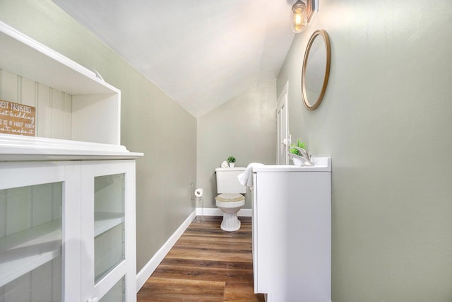 bathroom featuring hardwood / wood-style floors, vaulted ceiling, and toilet