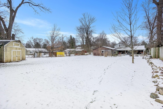 snowy yard with a storage shed