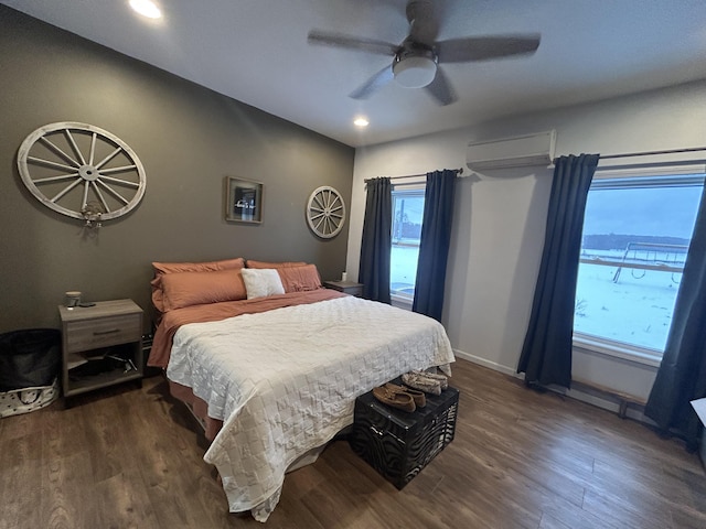 bedroom with a wall mounted air conditioner, multiple windows, dark hardwood / wood-style floors, and ceiling fan