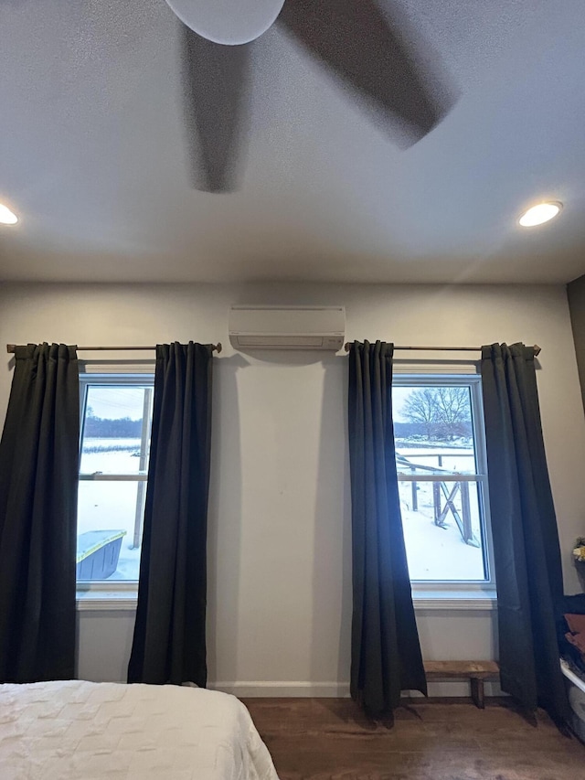 bedroom featuring a wall mounted AC and dark wood-type flooring