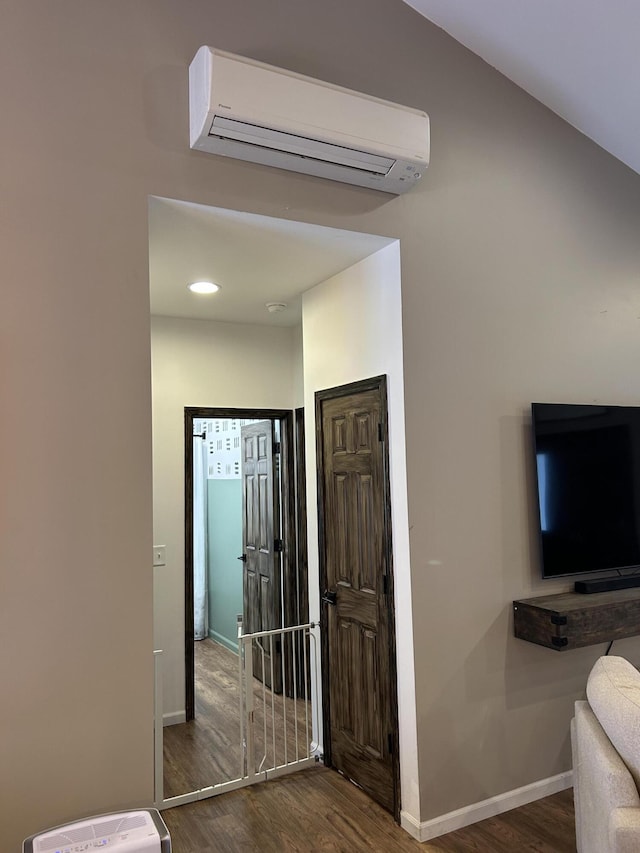 interior space featuring a wall unit AC and dark wood-type flooring