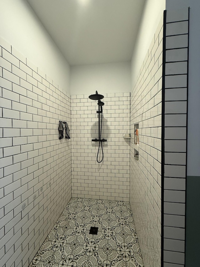 bathroom featuring a tile shower and tile patterned flooring