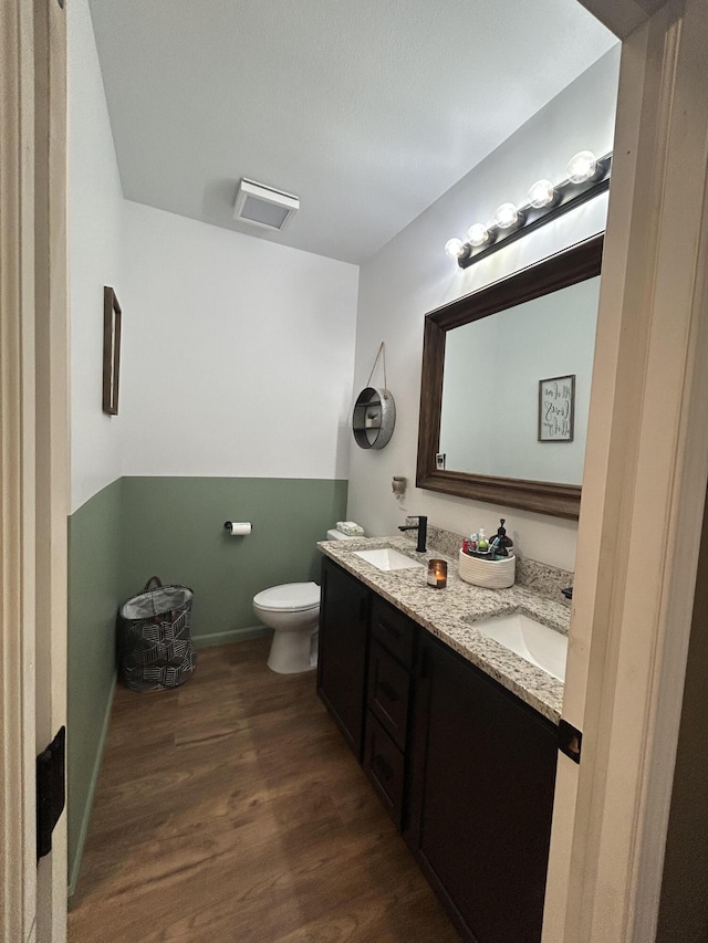 bathroom with hardwood / wood-style flooring, vanity, and toilet