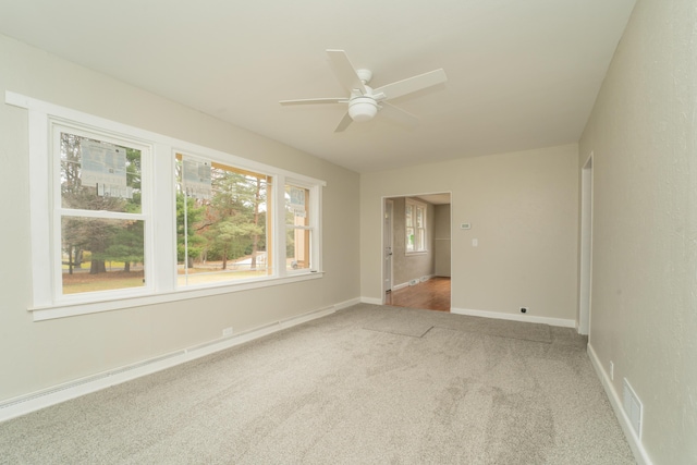 unfurnished room with carpet flooring, ceiling fan, and plenty of natural light