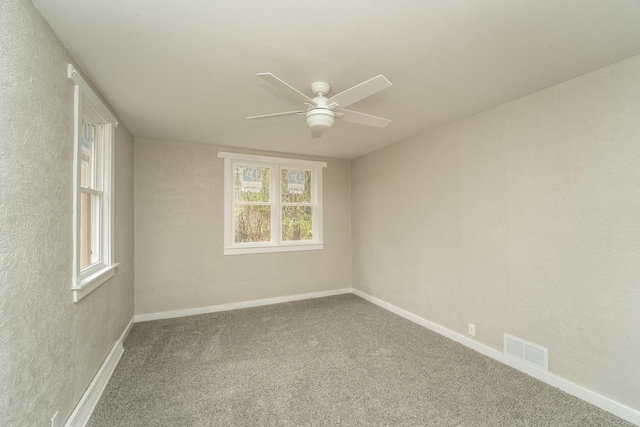 carpeted spare room featuring ceiling fan