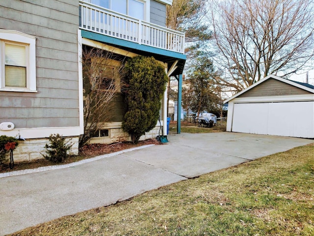 exterior space featuring an outbuilding, a balcony, and a garage