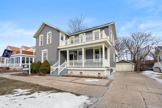 front of property with a shed, a garage, a balcony, and covered porch