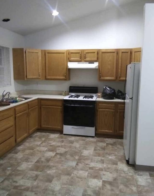 kitchen with sink, white appliances, and lofted ceiling