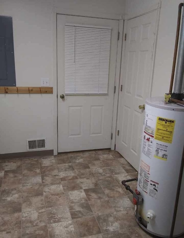 doorway to outside featuring electric panel and water heater