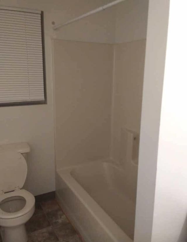 bathroom with toilet and  shower combination