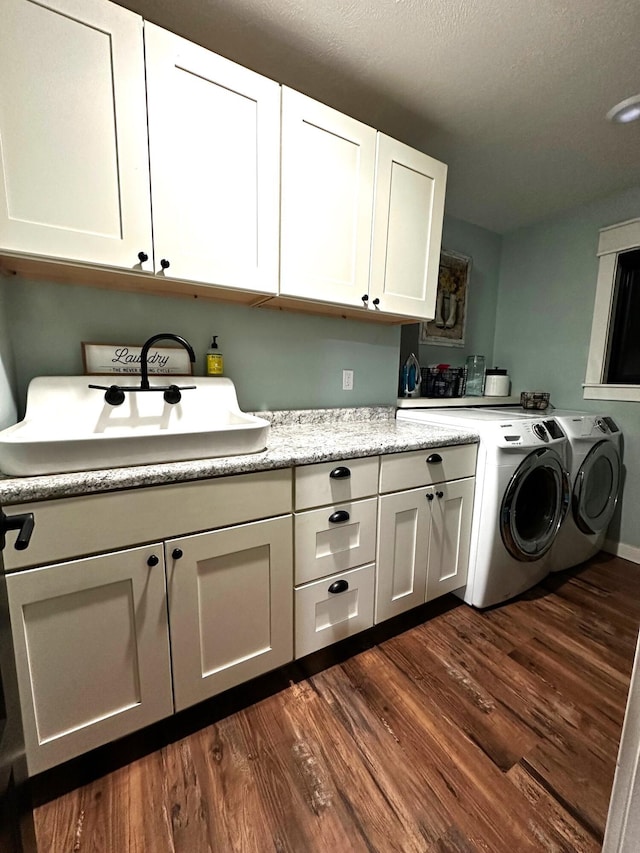 laundry room with cabinets, washing machine and dryer, and dark hardwood / wood-style floors